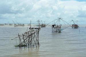 zeegezicht met menigte van traditionele visserijhulpmiddelen in de zee met horizon op achtergrond foto