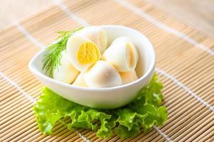gekookt eieren voedsel, kwartel eieren Aan wit schaal, ontbijt eieren met vers kwartel eieren en groente sla Aan tafel achtergrond foto