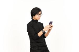 Holding en gebruik makend van smartphone met boos gezicht van knap Aziatisch Mens geïsoleerd Aan wit achtergrond foto