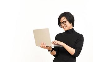 staand en gebruik makend van laptop van knap Aziatisch Mens geïsoleerd Aan wit achtergrond foto