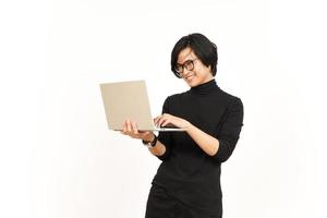 staand en gebruik makend van laptop van knap Aziatisch Mens geïsoleerd Aan wit achtergrond foto