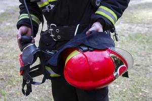 brandweerman. handen van een brandweerman met een helm en een masker. foto