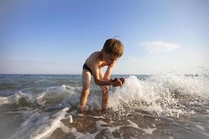 kind Aan vakantie. een jongen is spelen Bij zee. foto