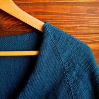 handgemaakt trui. gebreid kleding stof van een groen draad Aan een bruin achtergrond. foto
