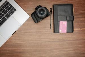 een laptop en een camera Aan een houten tafel foto