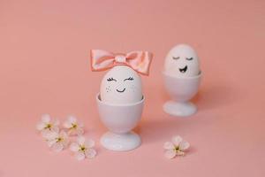 eieren met gezicht en bloemen Aan de roze boog, voor Pasen achtergrond foto