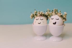 een wit ei met een gezicht gemaakt van bloemen zit in een ei schelp met een geel bloem Aan het. foto