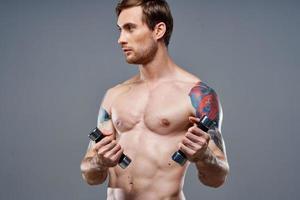 vent met een naakt torso gemotiveerd omhoog arm spieren halters geschiktheid bodybuilding sport- foto