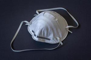 bouw masker Aan de gezicht naar beschermen de ademhalings kanaal van stof. beschermend beademingsapparaat. donker achtergrond. horizontaal. foto
