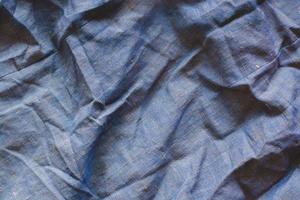 de structuur van de kleding stof. ruw, dicht kleding stof. heel gerimpeld. blauw en geel draden. foto