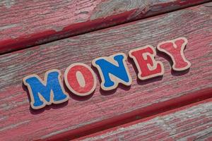 woord geld gemaakt van houten brieven Aan oud bord foto
