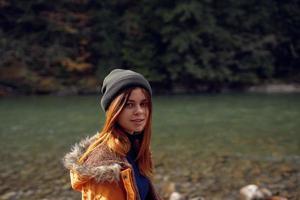 vrouw wandelen in de buurt de rivier- gedaald bladeren natuur bergen foto