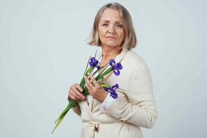 ouderen vrouw met een boeket van bloemen geschenk zorgzaam verjaardag foto