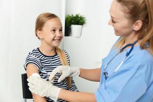 vrouw dokter injecties in de arm van een kind in de ziekenhuis Gezondheid zorg covid vaccinatie foto