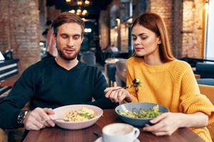 Mens en vrouw aan het eten Bij de restaurant Bij de tafel communicatie rust uit foto