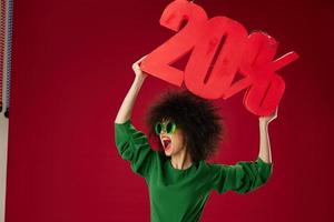 schoonheid mode vrouw gekruld kapsels groen jurk twintig procent korting rood achtergrond ongewijzigd foto