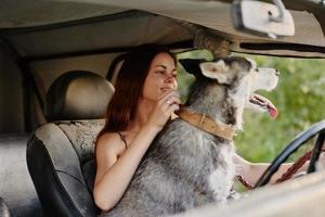 vrouw en haar schor hond gelukkig op reis in auto glimlach met tanden herfst wandelen met huisdier, reizen met hond vriend foto
