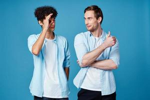 jong mannen in identiek t-shirts en blauw overhemden chatten vrienden foto