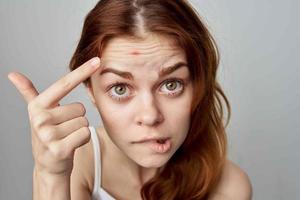 vrouw met puistje Aan haar gezicht emoties hygiëne schoonheidsspecialiste foto