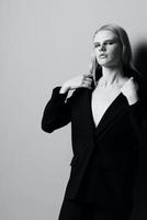 een elegant vrouw houdt een jasje halsband terwijl poseren in de studio. modieus elegant foto. concept voor kleding merken foto