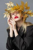 vrouw gouden bladeren Aan de hoofd in zwart jasje studio model- ongewijzigd foto