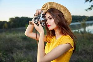 vrouw fotograaf in hoed op zoek in de camera lens glimlach natuur hobby foto