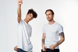 twee vrolijk vrienden in t-shirts emoties levensstijl licht achtergrond foto