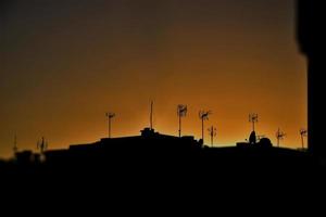 pittoreske landschap Bij zonsondergang met zwart daken van huizen en antennes foto