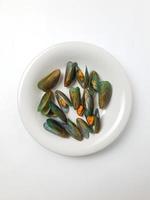 groen mossel Aan een bord Aan een wit achtergrond, vers nieuw Zeeland mossel of perna canaliculus Aan een wit achtergrond. geïsoleerd groen mosselen. foto