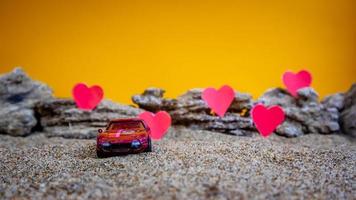 minahasa, Indonesië december 2022, speelgoed- auto met helling oranje achtergrond en een hart foto