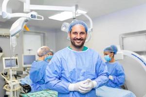 portret van mannetje chirurg in operatie theater op zoek Bij camera. dokter in scrubs en medisch masker in modern ziekenhuis in werking theater. foto