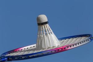 dichtbij omhoog van badminton racket met shuttle tegen blauw lucht foto