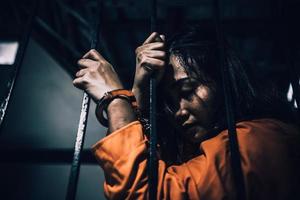 portret van vrouwen die wanhopig op zoek zijn naar de ijzeren gevangenis, het concept van de gevangene, de mensen van Thailand, hopen vrij te zijn, als de wet wordt overtreden, zou worden gearresteerd en gevangen gezet. foto