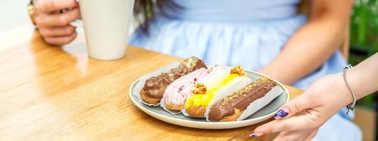 ober zet bord met eclairs foto