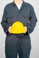 werknemer staande in blauwe overall met veiligheidshelm foto