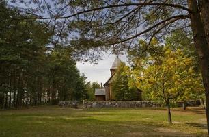 historisch houten kerk tussen herfst bomen in Polen foto
