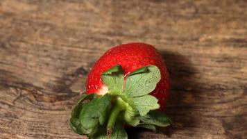 vers rood aardbei dichtbij omhoog Aan houten achtergrond foto