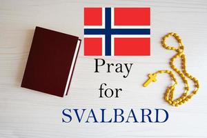 bidden voor Spitsbergen. rozenkrans en heilig Bijbel achtergrond. foto