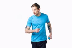 sportief Mens met een tatoeëren Aan zijn arm in een blauw t-shirt en spieren bodybuilding geschiktheid foto