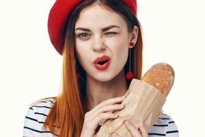 mooi Frans vrouw Holding een brood van gestreept t-shirt licht achtergrond foto