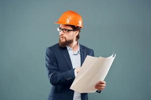 mannetje ingenieur met blauwdrukken in de handen van een oranje moeilijk hoed industrie professioneel foto