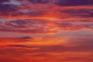 rood oranje Purper kleurrijk wolken in verduistering lucht Bij zonsondergang foto