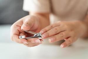 vrouw snijdend vingernagels gebruik makend van nagel klipper, gezondheidszorg, schoonheid concept. foto