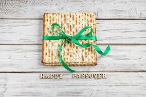 gelukkig pascha. matzah Aan een wit houten achtergrond. traditioneel Joods regulier vakantie van pesach. matzo brood. foto