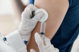 dokter geeft een injectie in de schouder geduldig covid vaccinatie foto