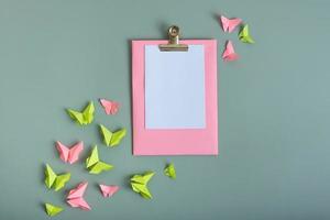 massage bord mockup met papier vlinders groen en roze kleur vlak leggen Aan een gekleurde achtergrond foto