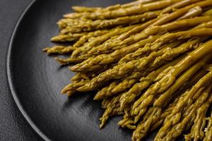 takjes van heerlijk ingeblikt asperges Aan een zwart keramisch bord foto