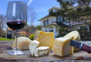 tafel met een glas van rood wijn en divers kazen foto