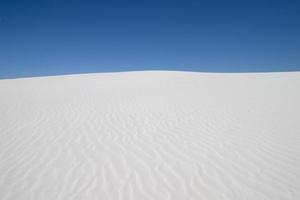 wit zand duin en blauw lucht foto