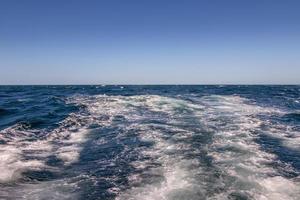 boot wakker worden en golven Aan de oceaan foto